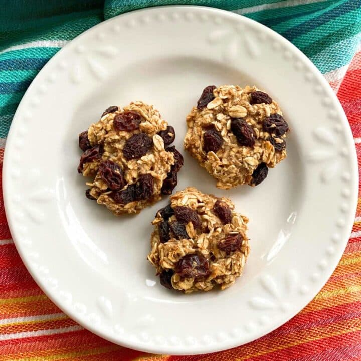 Three healthy banana oatmeal raisin cookies on a plate.