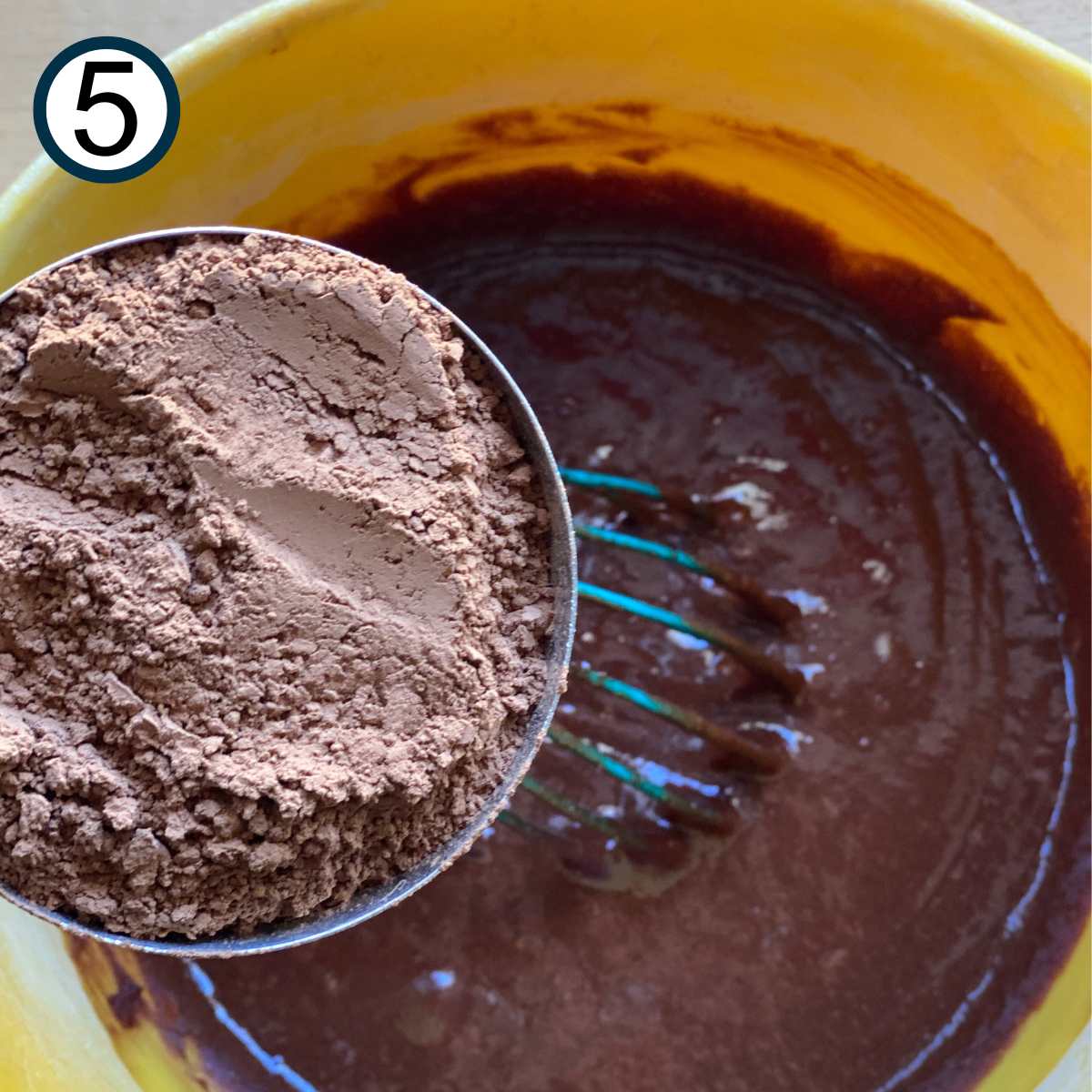 Cocoa powder being added to the chocolate and butter mixture for flourless chocolate cake.