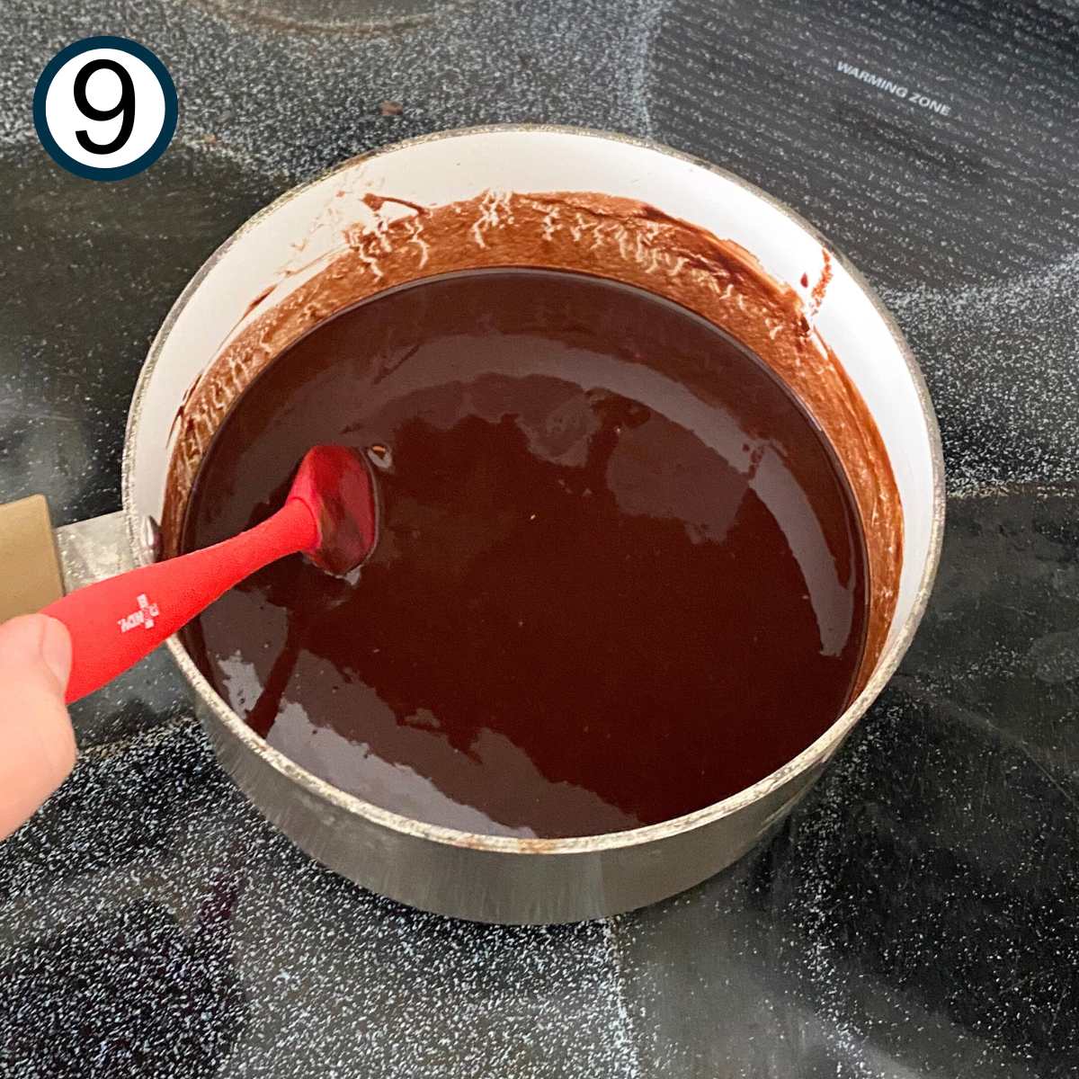 Ganache in a small sauce pan on top of a stove.