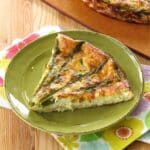 A slice of crustless asparagus quiche on a plate.