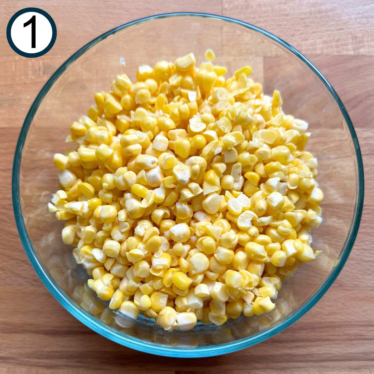Glass bowl with fresh corn kernels in it.