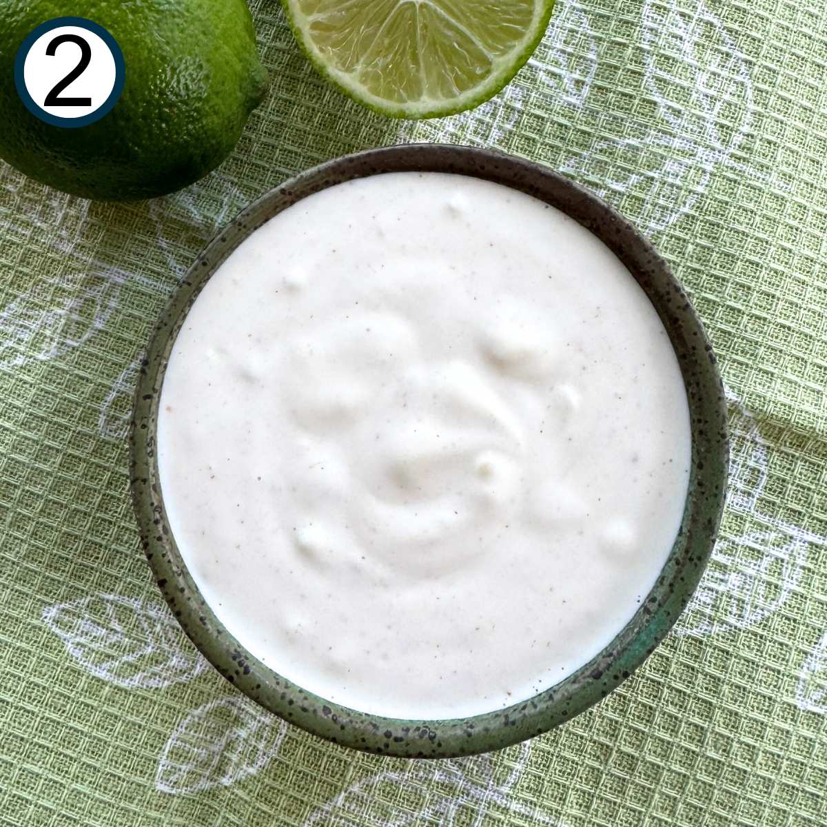 Mixture of mayonnaise, sour cream, lime juice, pressed garlic, and cayenne pepper in a small bowl.