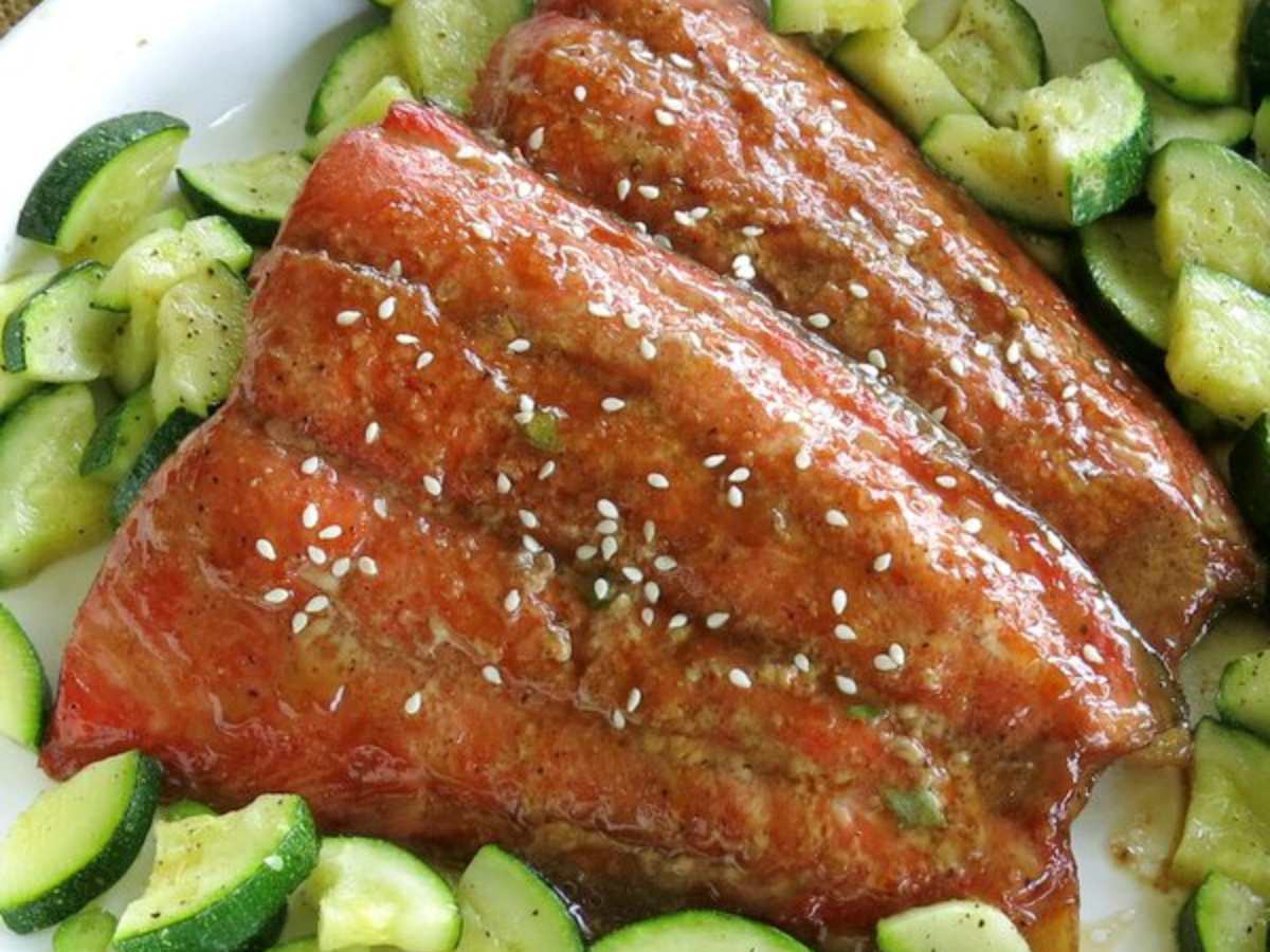 Two bourbon-marinated salmon fillets  surrounded by zucchini.