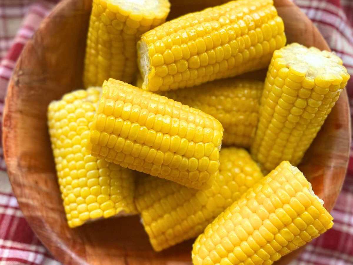 Corn on the cob cut into 4-inch segments in a wooden bowl.