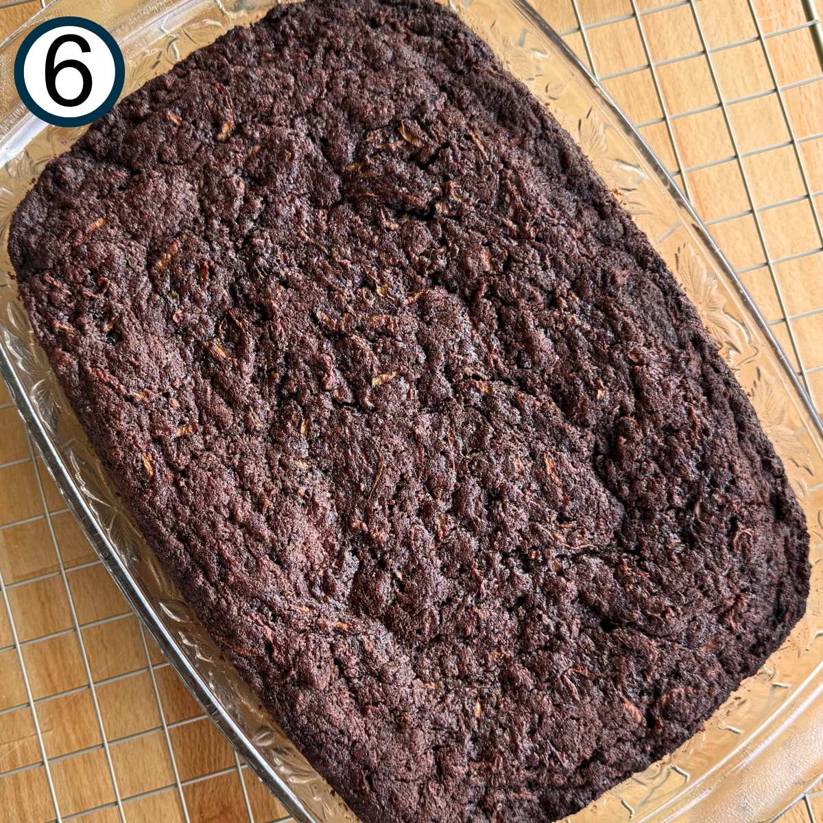 Cooked zucchini brownies in a glass baking dish on top of a wire rack.
