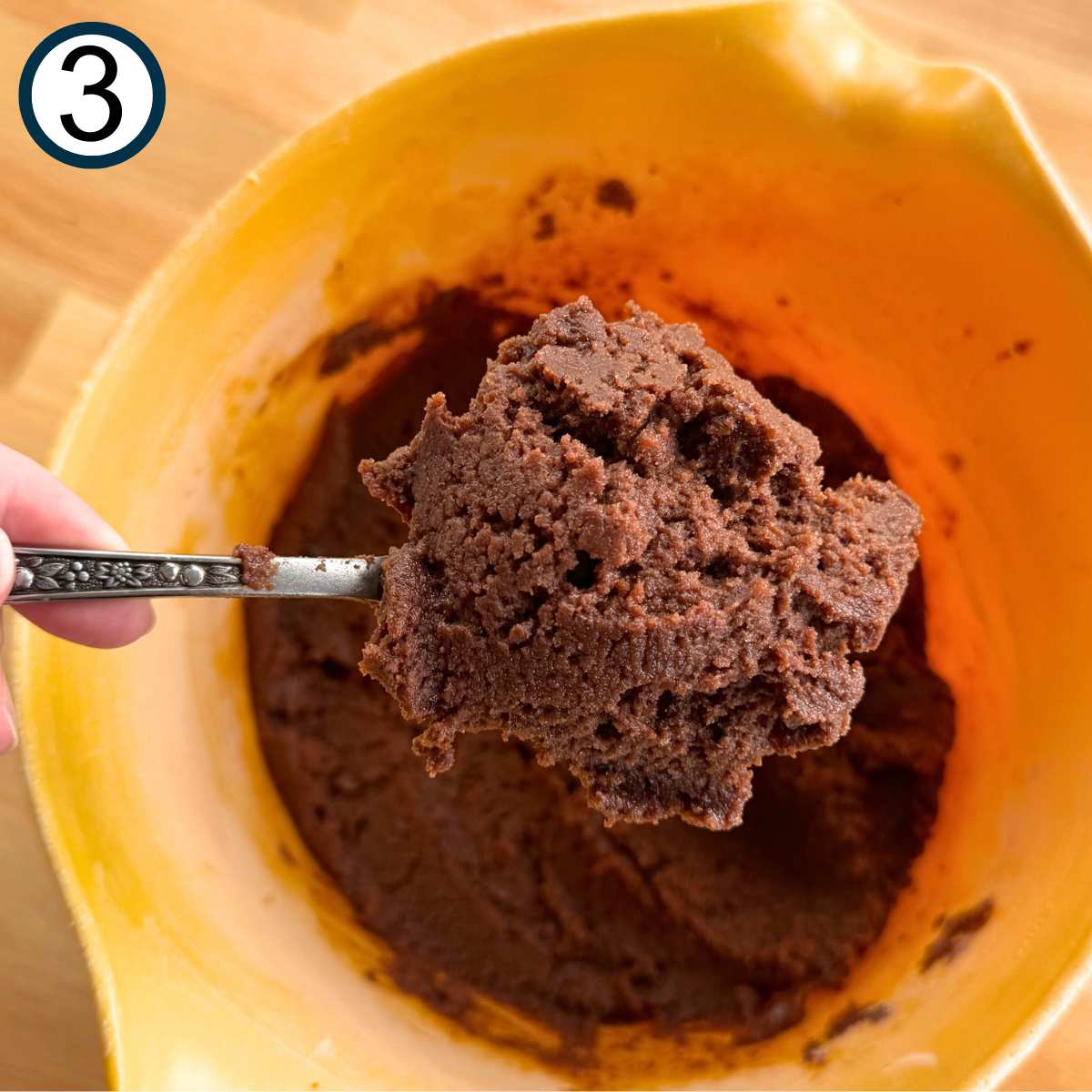 Spoon holding creamed wet and dry ingredients for zucchini brownies.