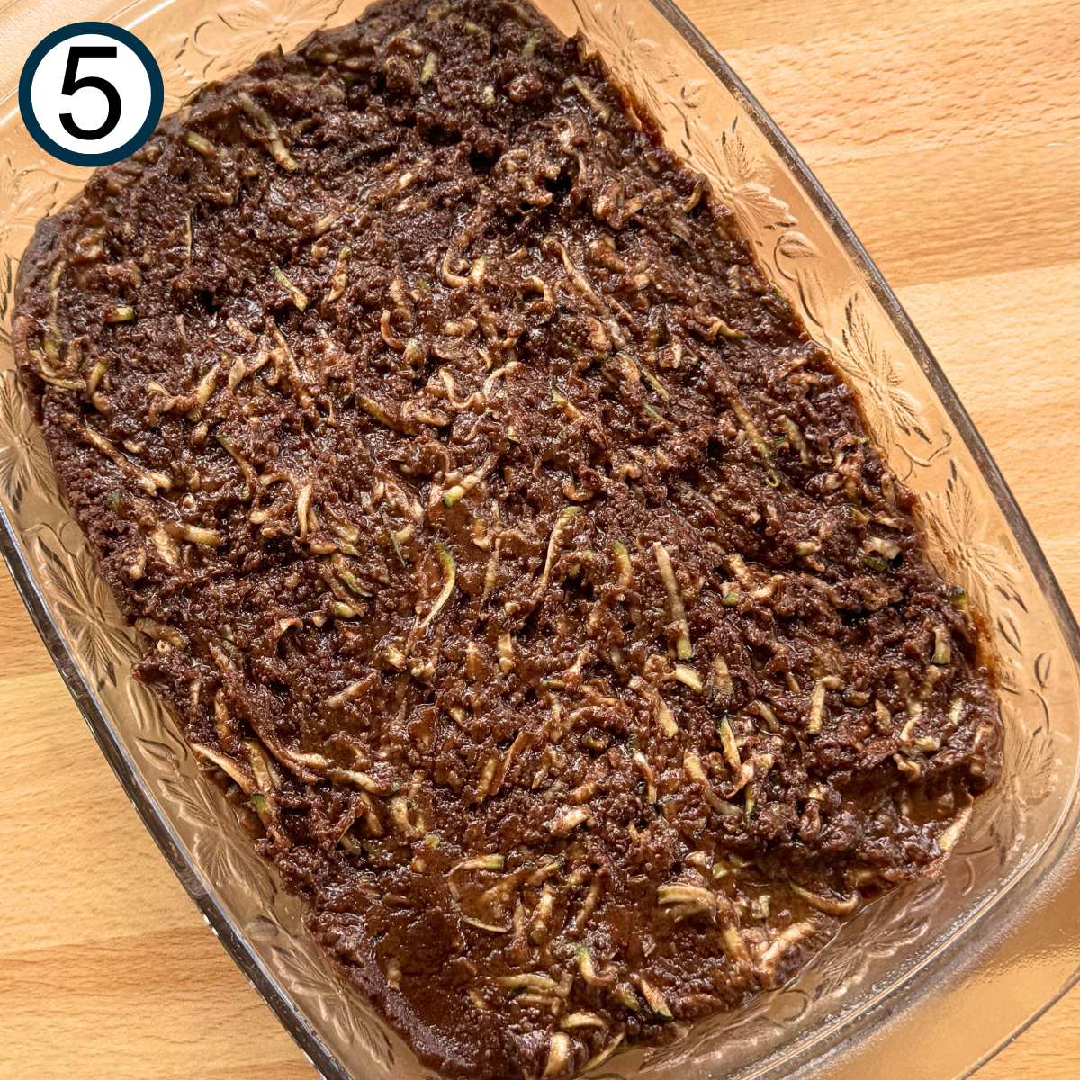 Uncooked zucchini brownies in a glass baking dish.