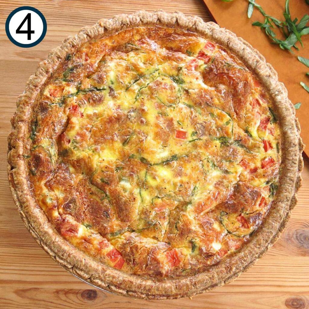 Cooked tomato bacon quiche on a butcher block counter.