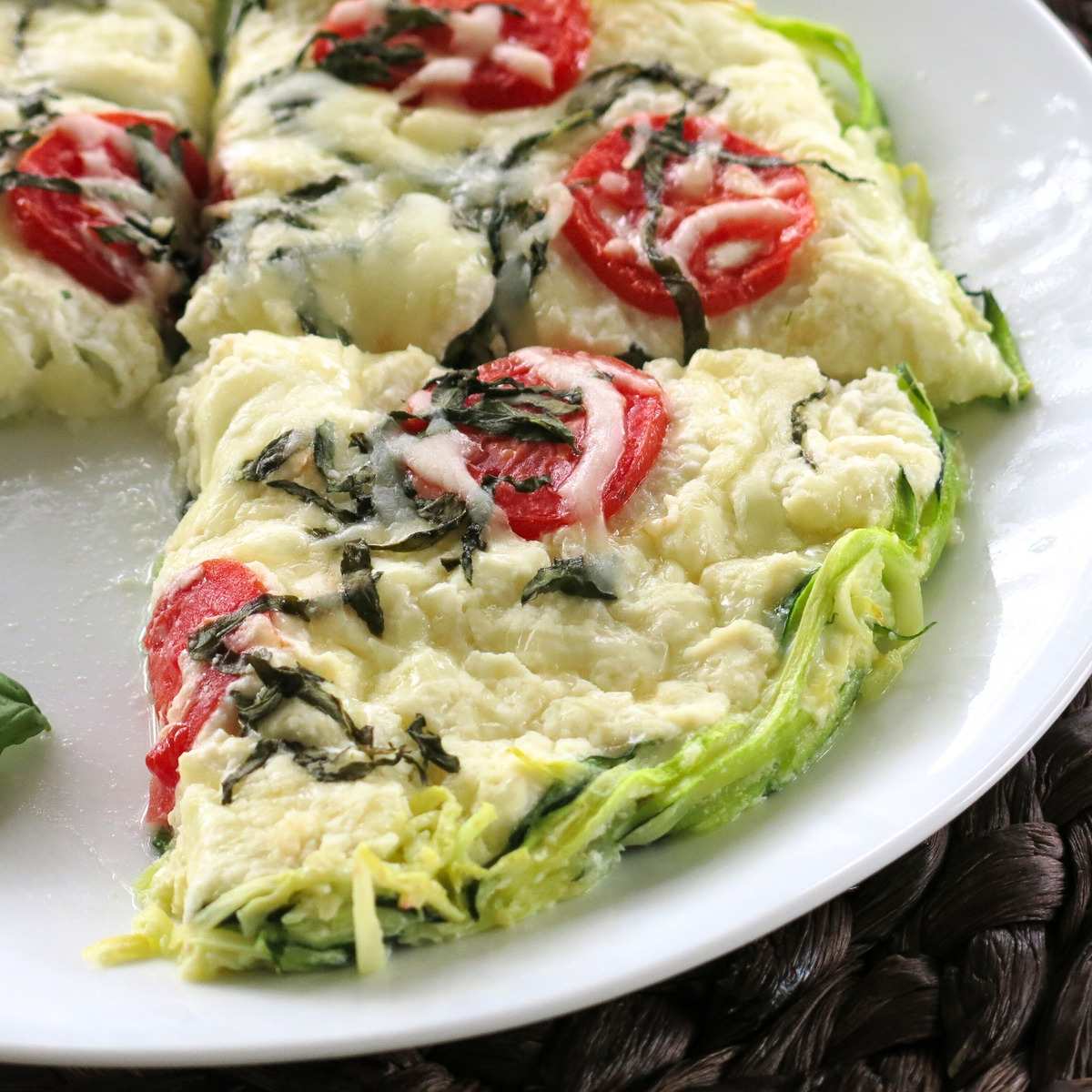 Slices of crustless zucchini pie made with spiralized zucchini noodles on a white plate.