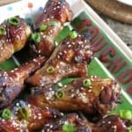 Sticky baked chicken wings made with molasses, honey, and garlic, on a platter.