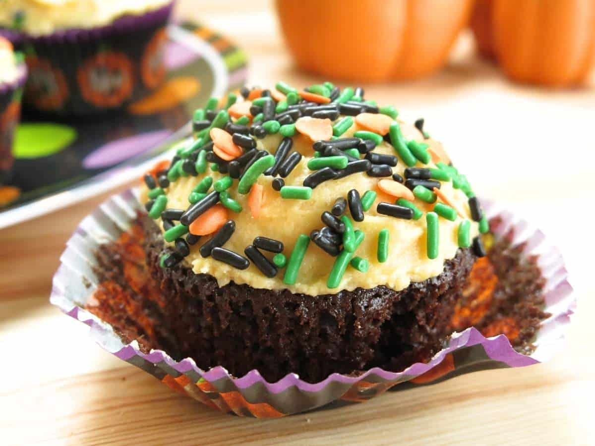 Eggless chocolate pumpkin cupcake in a wrapper on a table.