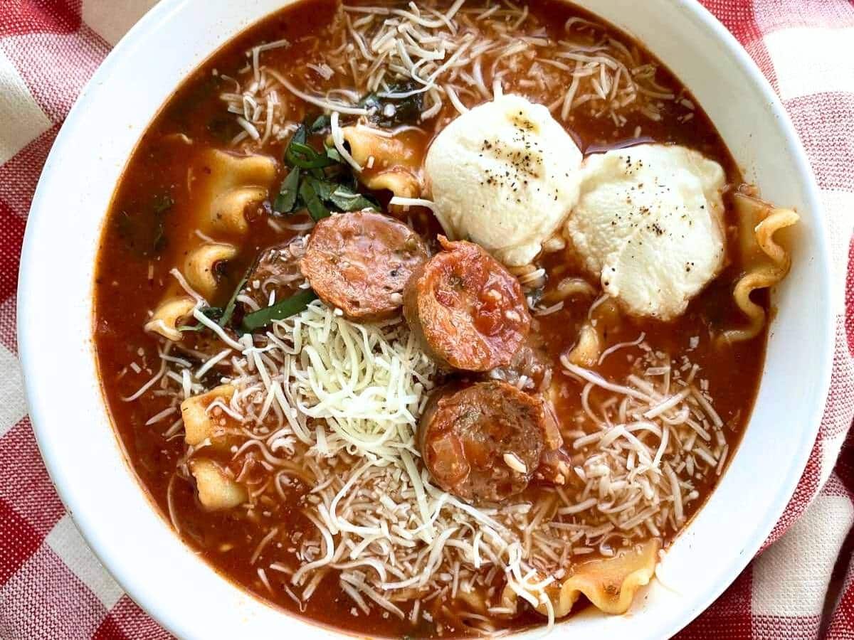 Bowl of lasagna soup topped with dollops of ricotta cheese.