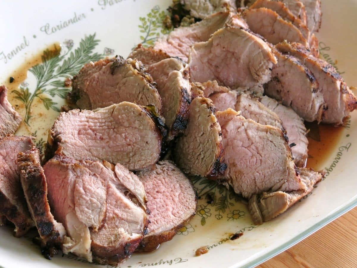 Platter of cooked and sliced pork tenderloin.