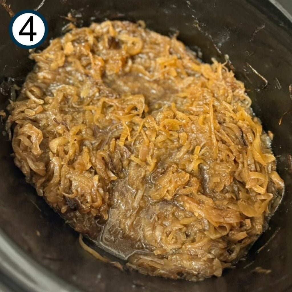 Mostly cooked caramelized onions in the crock of a slow cooker.