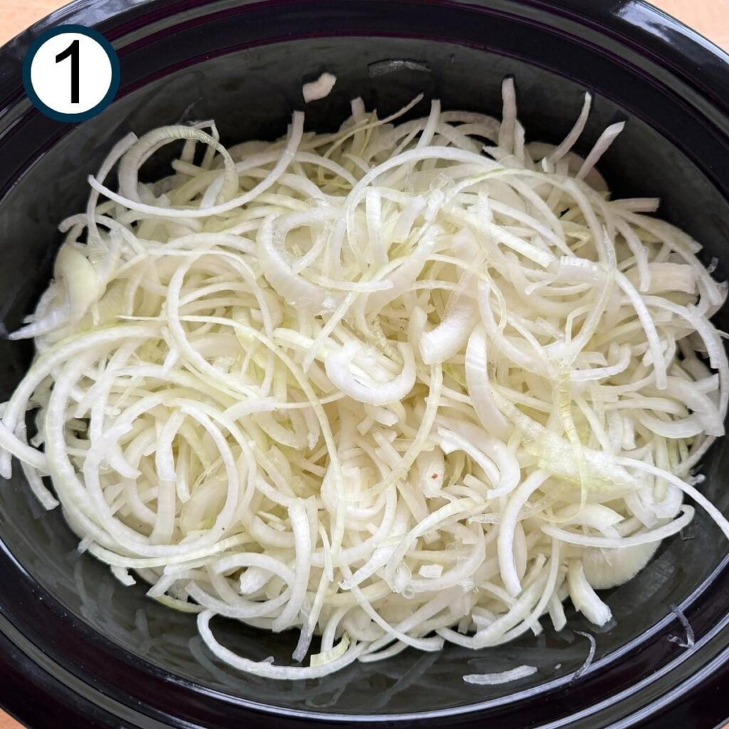 Thinly sliced onions in a slow cooker.
