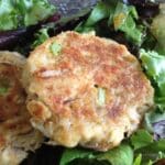 Maryland-style crab cake made without eggs on mixed salad greens.