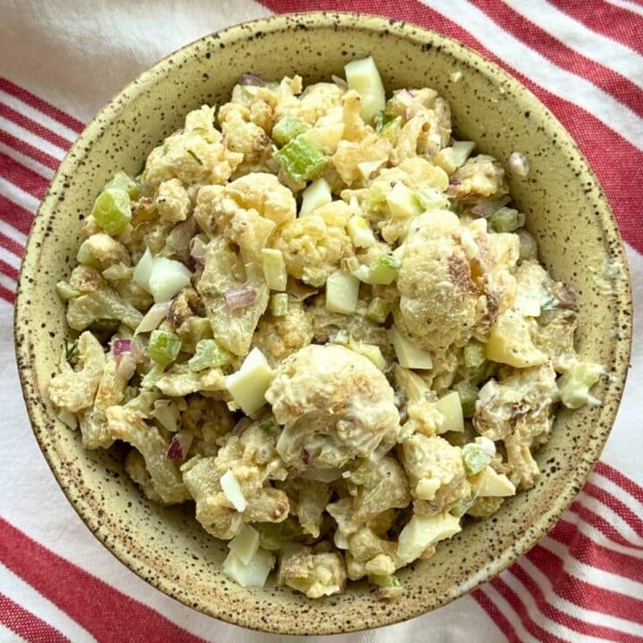 Roasted cauliflower potato salad from frozen cauliflower with a Greek yogurt dressing in a light brown bowl.