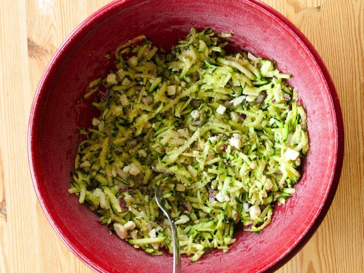 Zucchini egg muffin mixture in a red bowl.