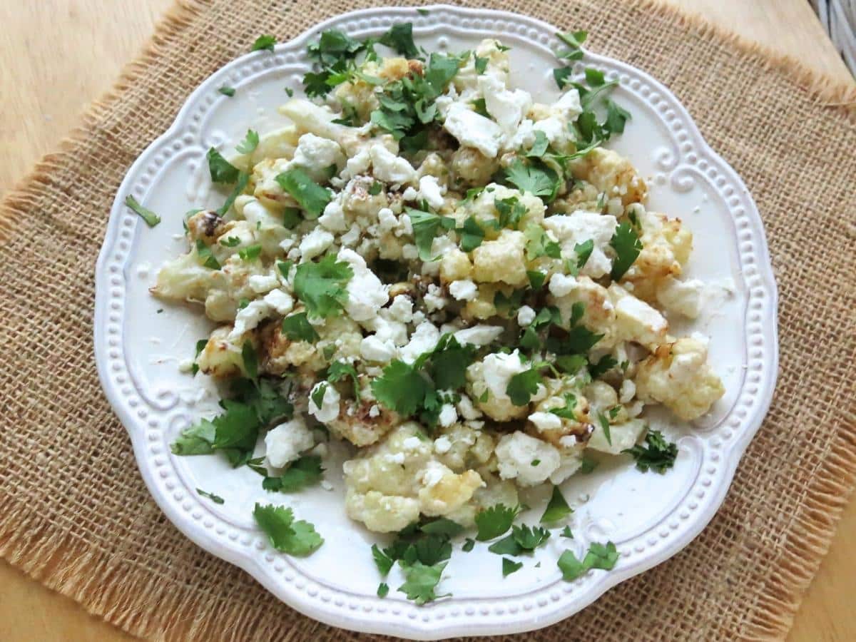 Cauliflower elote with charred cauliflower, topped with cream, Cotija, and chopped cilantro.