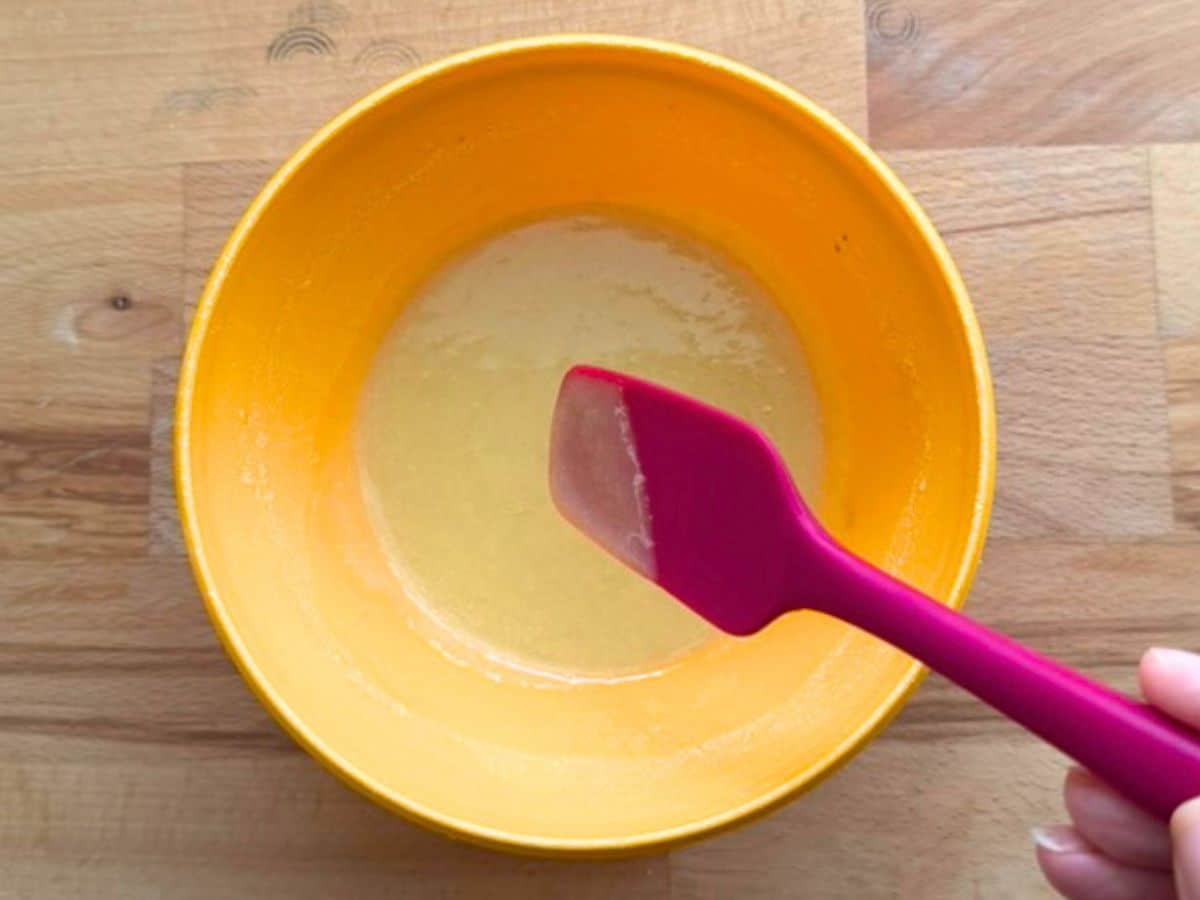 Orange bowl with honey mustard ingredients mixed.