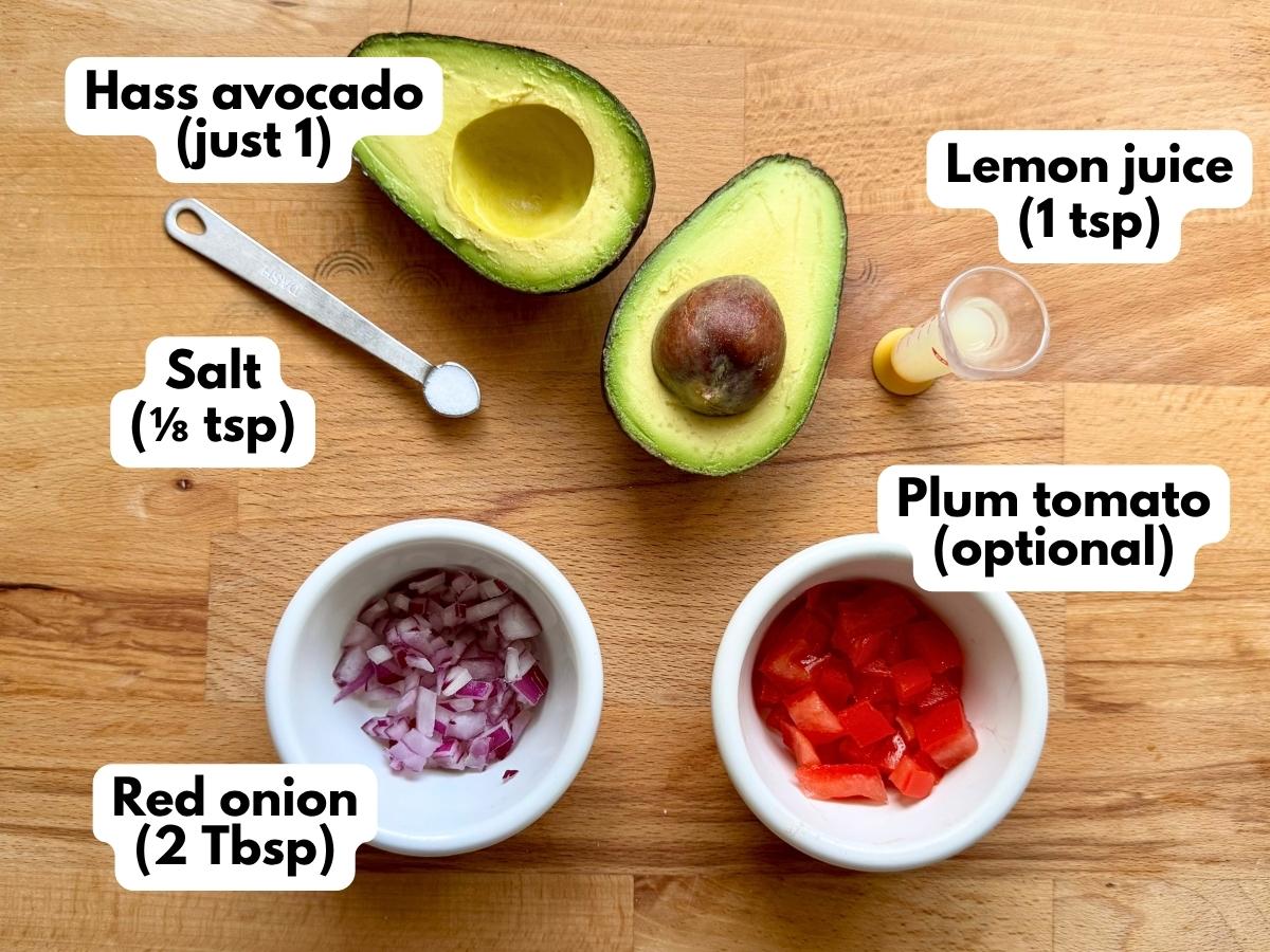 Hass avocado, lemon juice, salt, diced red onions, and diced plum tomotoes with labels on a cutting board.