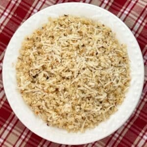 Roasted cauliflower rice made with frozen riced cauliflower, garlic and Parmesan cheese in a white bowl.