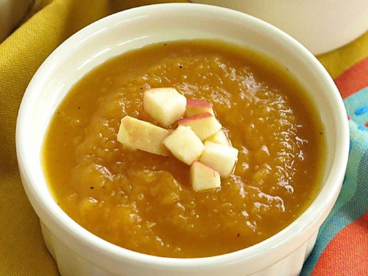 Close-up of butternut squash apple soup topped with diced apple. 