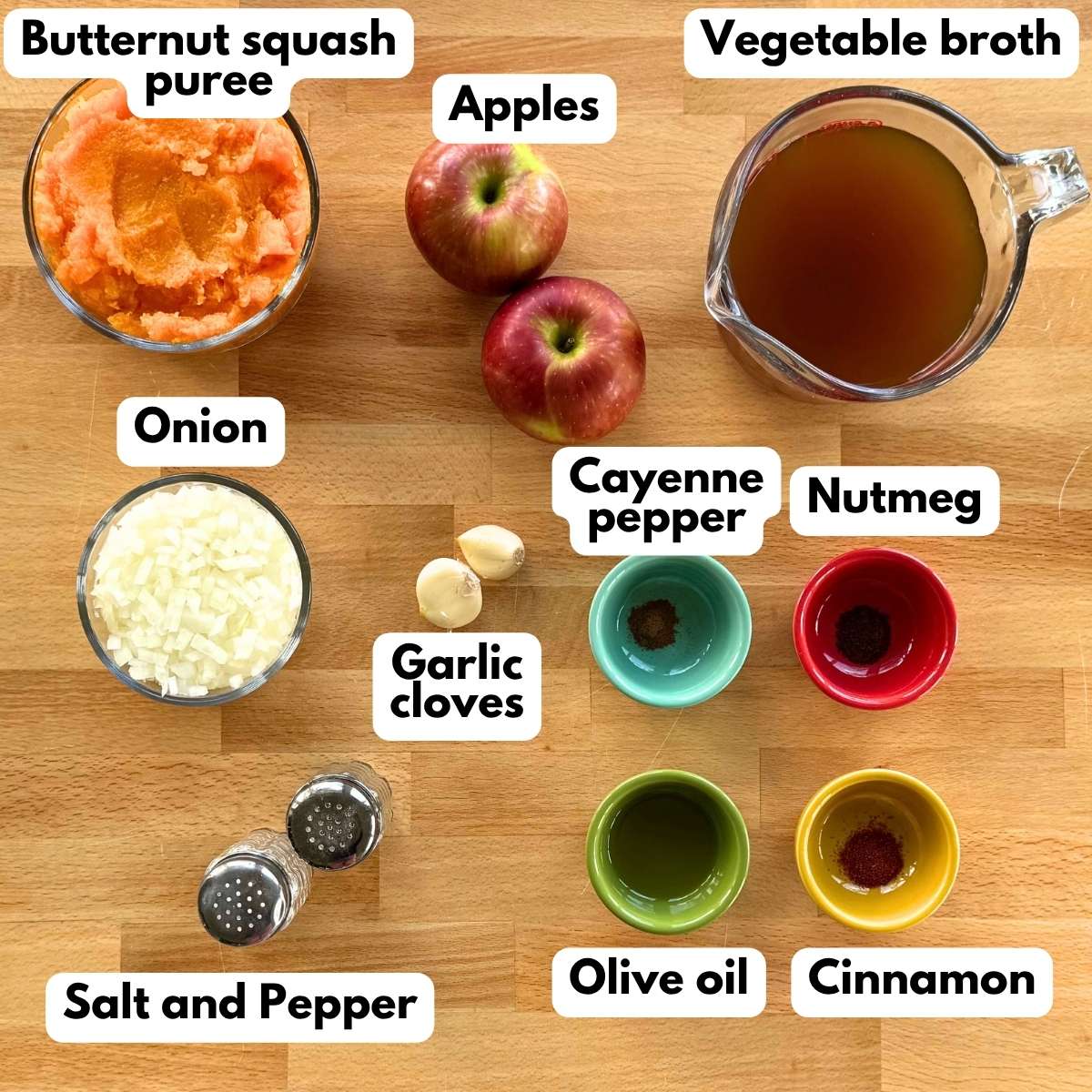 Ingredients for butternut squash soup with apple, including squash puree, apples, vegetable broth, onion, garlic, cayenne, cinnamon and nutmeg.