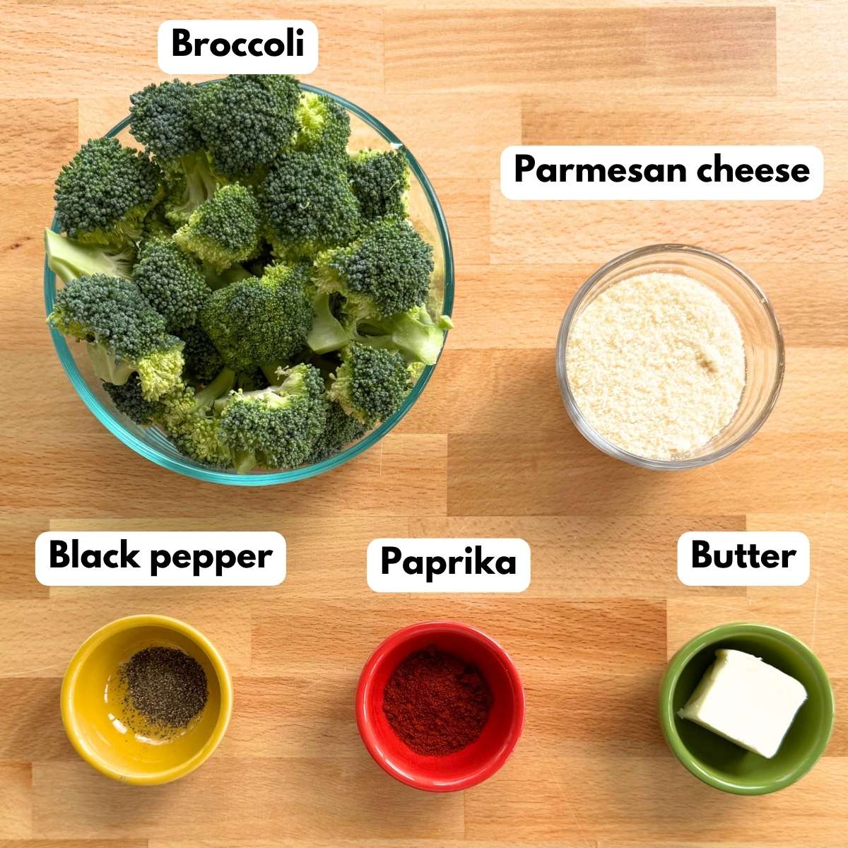 Ingredients for crispy Parmesan broccoli bites: broccoli florets, Parmesan cheese, butter, paprika, and black pepper.