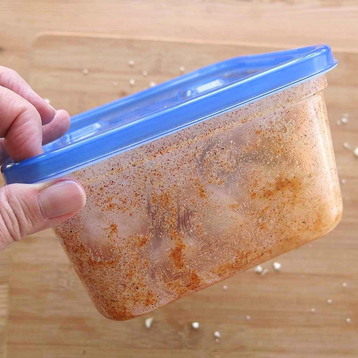 Cauliflower florets tossed with Parmesan and seasonings in a covered container.