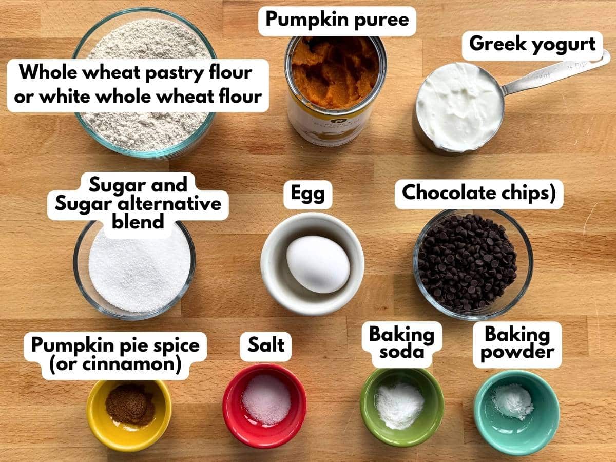 Ingredients for Greek yogurt pumpkin muffins, including pumpkin puree, whole wheat flour, Greek yogurt, egg, sweetener, and chocolate chips.