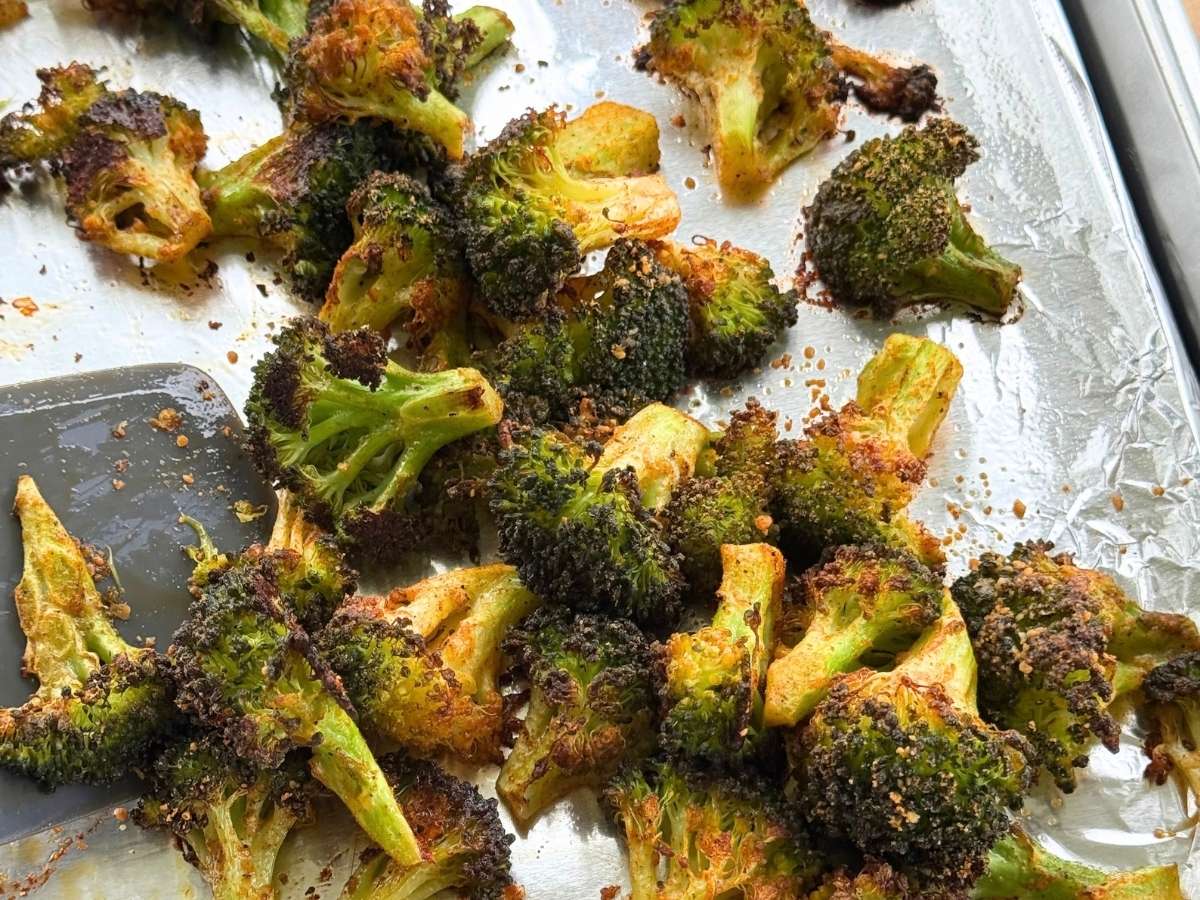 Crispy Parmesan broccoli bites roasted until browned on a baking sheet.