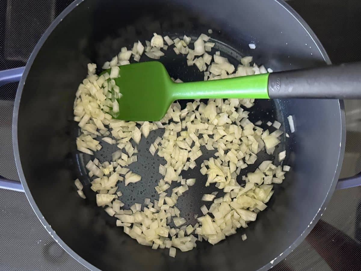 Diced onion sautéing in a pot for shrimp tortilla soup before garlic and spices are added.