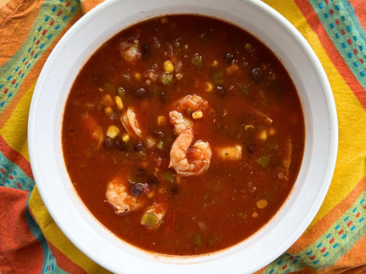 Finished shrimp tortilla soup with cooked shrimp, black beans, corn, and tomatoes in the pot before toppings are added.