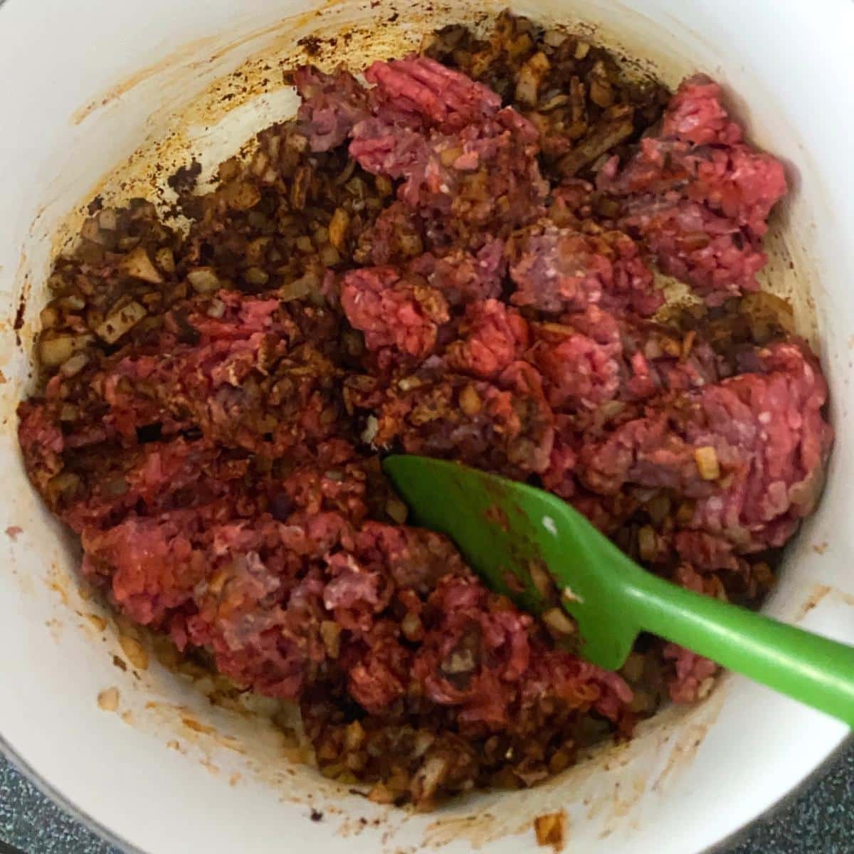 Ground beef browning with onion and spices for Southern chili.