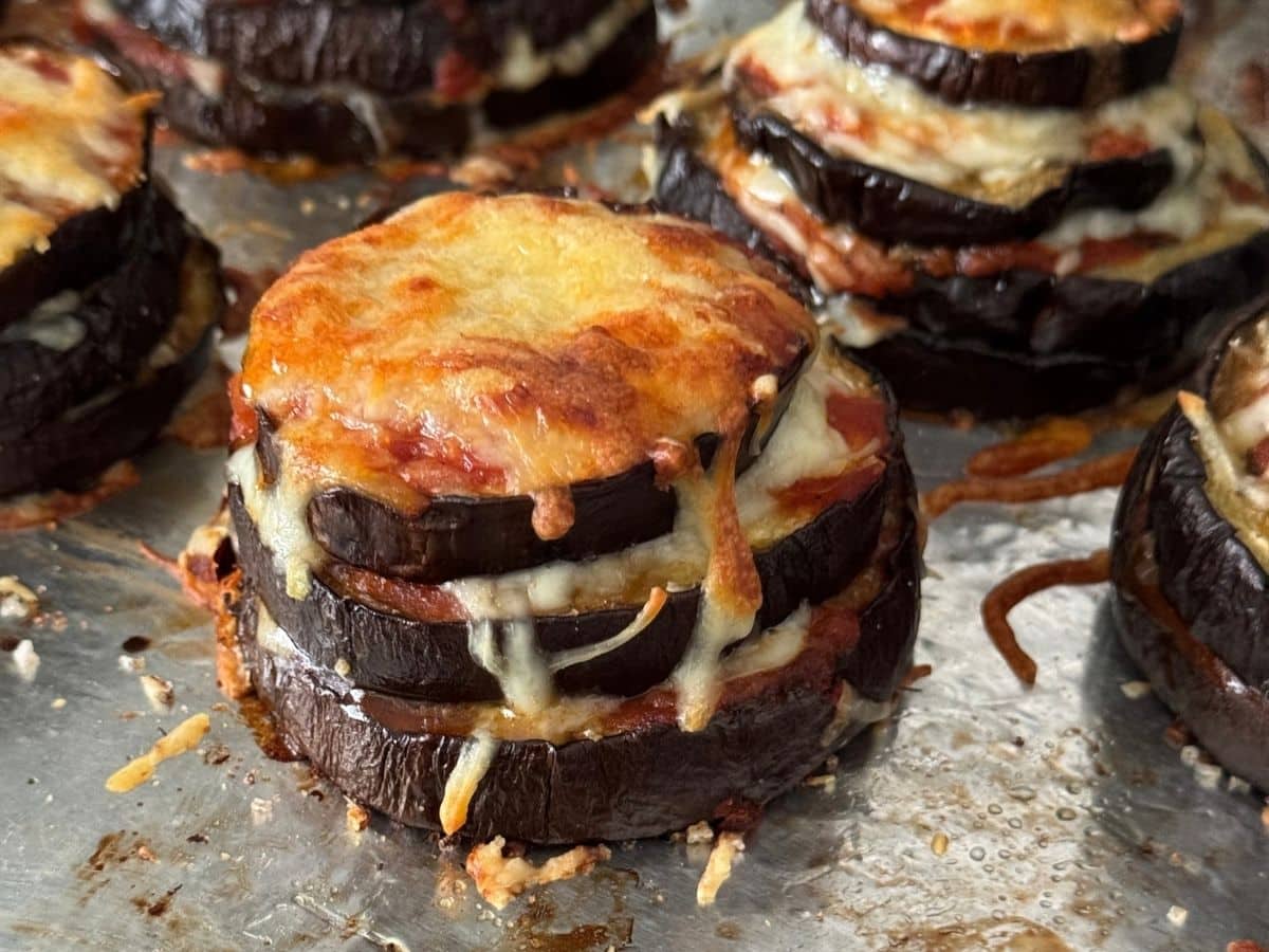 Baked eggplant Parmesan stack with melted golden cheese and marinara between the layers.
