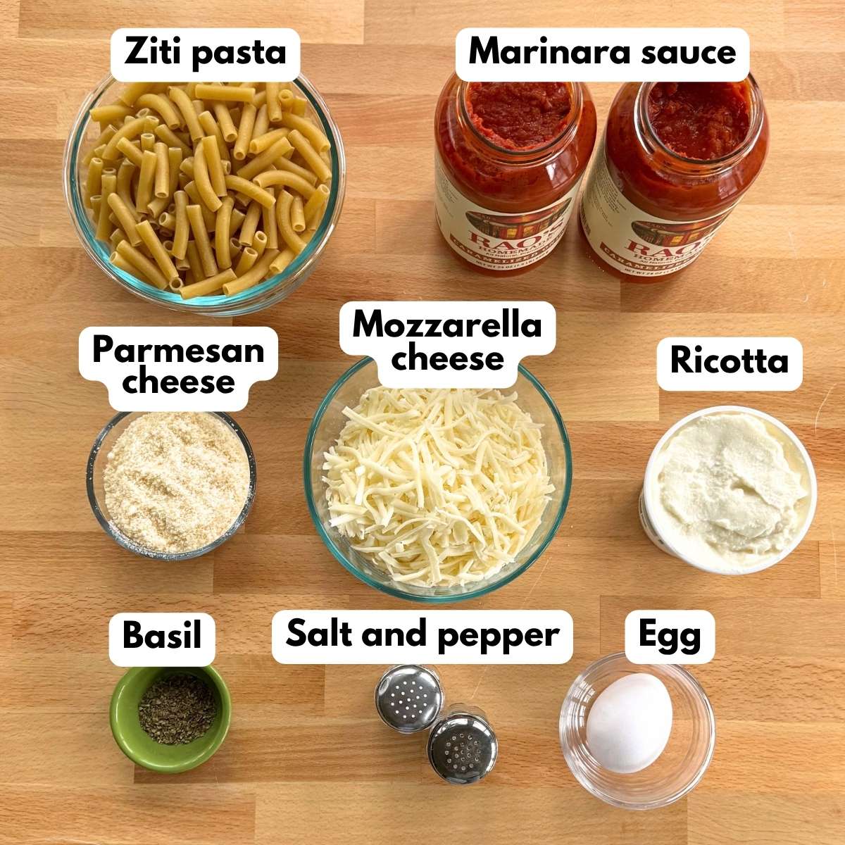 Ingredients for crockpot baked ziti including ziti pasta, marinara sauce, ricotta, mozzarella, Parmesan, egg, basil, salt, and pepper.